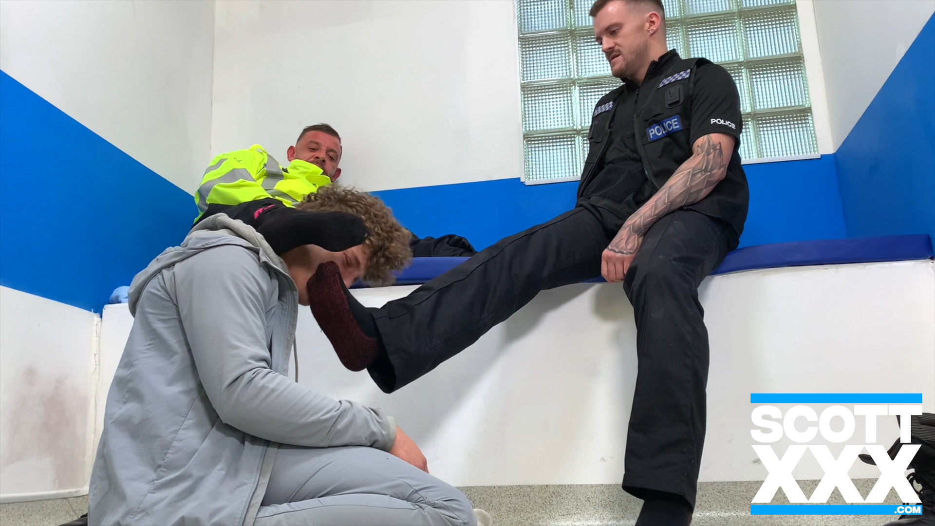 Policemen put their sweaty socked feet in a fit scally chav lads face in the cells